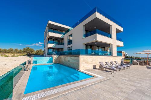 a villa with a swimming pool in front of a building at Villa Tadic in Zadar