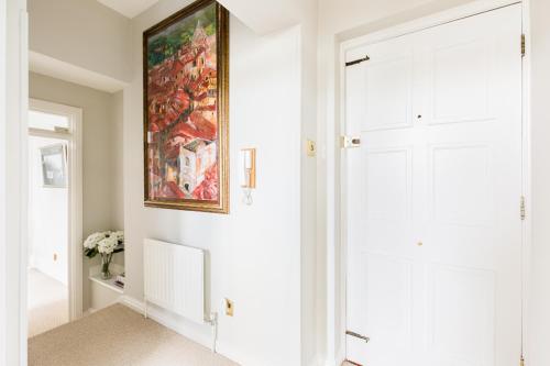 een witte hal met een schilderij aan de muur bij Warwick Victorian Apartment in Warwick