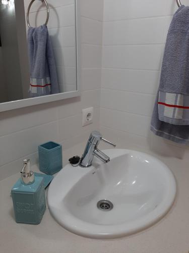 a white sink in a bathroom with a mirror at PRECIOSO DUPLEX EN CALA SANTANDRIA CON PISCINA Y WIFI in Son Carrio
