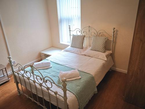 a bedroom with a bed with two towels on it at J BOOK NOW, Spacious 5 Bed Sleeps 9 Long Stays Workers & Families by Your Night Inn Group in Wolverhampton