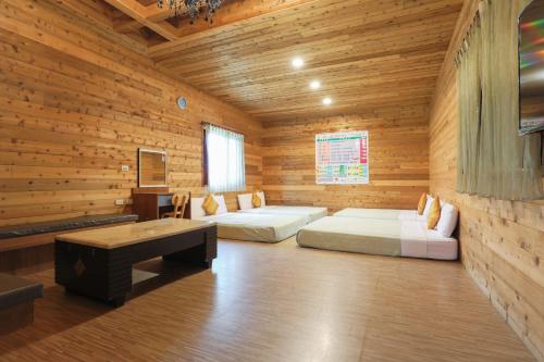 a room with two beds and a desk in a wooden room at Hai Yuan Bungalow II in Kenting