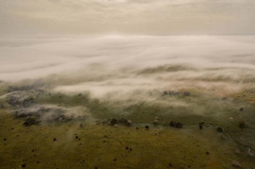 a group of people standing on a hill in the clouds at Taita Hills Safari Resort & Spa in Tsavo