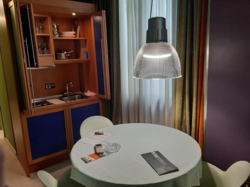 Biały stół i krzesła w pokoju z lampką w obiekcie Apartaments Sant Jordi Girona 97 w Barcelonie