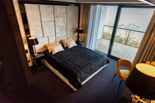 a bedroom with a bed and a large window at Golden Eye Apartament Seaside Park in Kołobrzeg