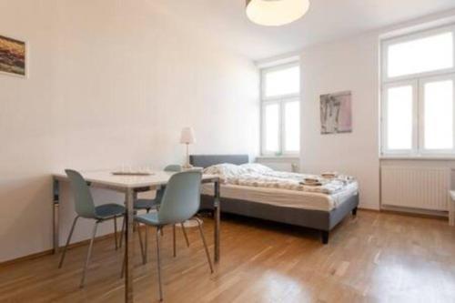 a bedroom with a bed and a table and chairs at Premium Aufenthalt l LF23 in Vienna