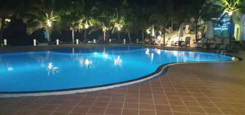 a large swimming pool with blue water at night at Muine Pacific Resort in Mui Ne