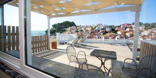 a balcony with chairs and a view of the city at San Nectarios in Parga