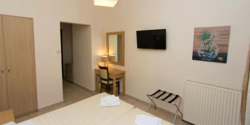 a room with a desk and a television on a wall at San Nectarios in Parga