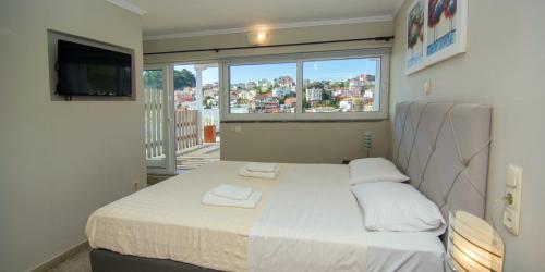 a bedroom with a bed and a large window at San Nectarios in Parga