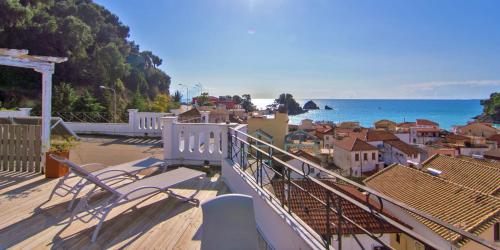 a balcony with a view of a town and the ocean at San Nectarios in Parga
