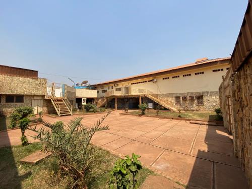 a courtyard of an old building with a staircase at Hotel Levy's in Bangui