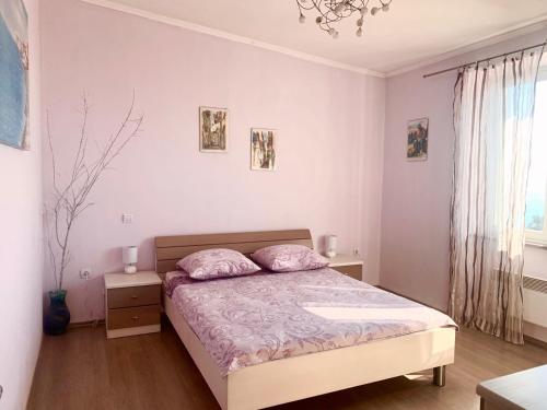 a bedroom with a bed with pink pillows on it at Apartment Kosović in Dubrovnik