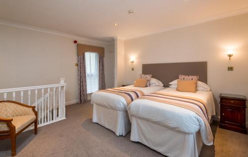 two beds in a room with a staircase at Glen-Yr-Afon House Hotel in Usk