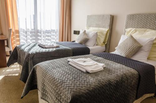a hotel room with two beds with towels on them at Hotel Rokoko in Košice