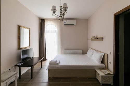 a bedroom with a bed and a desk and a window at Villa Ciao - Adults Only in Corbu