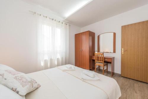 a bedroom with a bed and a desk with a mirror at Apartment Miriam with grill and terrace - by TA Leut Agency in Privlaka