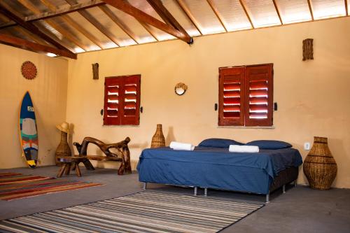 a bedroom with a bed and a surfboard in a room at Beach House- KiteAliCori in Ponta do Anel