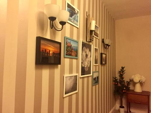a hallway with pictures on a striped wall at Mid-Wales Farmhouse, swimming pool, tranquil countryside views, sleeps 14 in Meifod