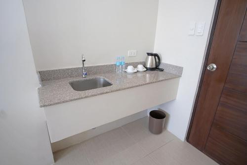 a kitchen counter with a sink in a room at Sukro in Bacolod