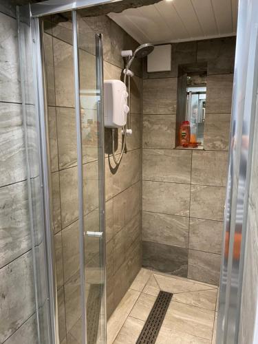 a shower with a glass door in a bathroom at garden view apartment in Bangor
