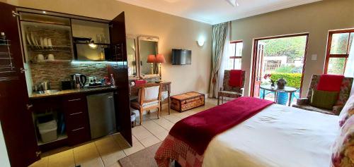 a bedroom with a bed and a kitchen in it at The Mandyville Jeffreys Bay in Jeffreys Bay