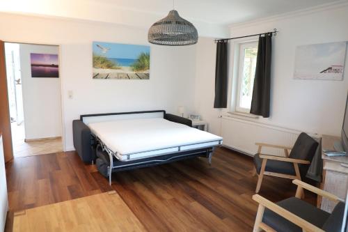 ein Zimmer mit einem Bett und einem Stuhl darin in der Unterkunft Haus Anker in Sankt Peter-Ording