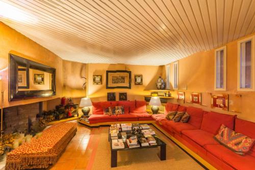 a living room with red couches and a tv at Villa Anna Maria in Centobuchi