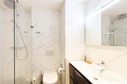 een badkamer met een douche, een toilet en een wastafel bij Citadines Sloterdijk Station Amsterdam in Amsterdam