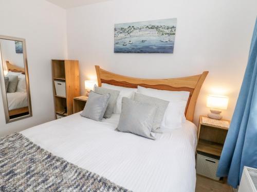 a bedroom with a bed with white sheets and pillows at 10 The Orchard in Colwyn Bay