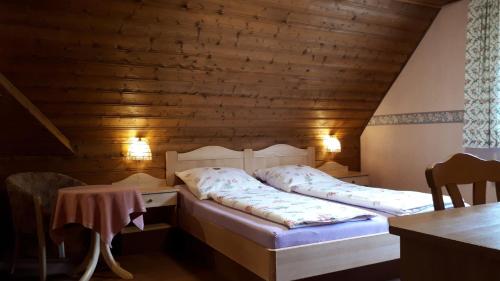 1 dormitorio con 2 camas en una habitación con paredes de madera en Gästehaus "Gisela" im fürstlichen Fischhaus, en Schillingsfürst