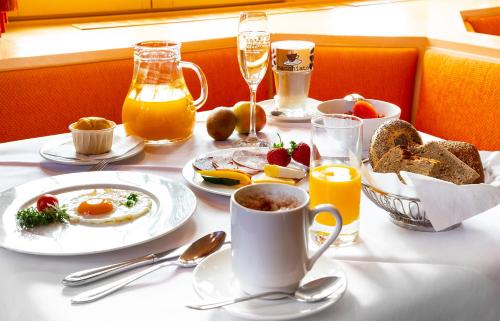a table with plates of breakfast food and drinks at Bio- und Wellnesshotel Alpenblick in Höchenschwand