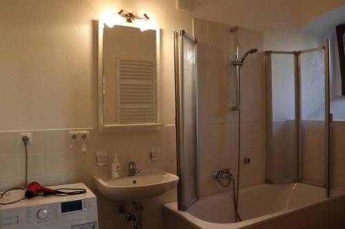 y baño con ducha, lavabo y bañera. en Ferienwohnung-im-Pfarrhaus, en Müglitztal