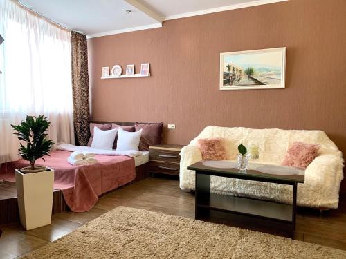 a living room with a bed and a couch at Apartment Alla in Chernihiv