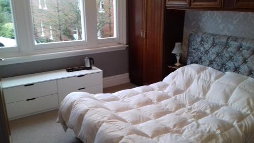 a bedroom with a white bed and a window at Lansdown House Bed & Breakfast in Market Drayton