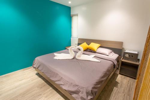 a bedroom with a bed with two pairs of white shoes at Bohol Sojourn Villa Alona in Panglao