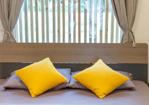 two yellow pillows sitting on top of a bed at Bohol Sojourn Villa Alona in Panglao