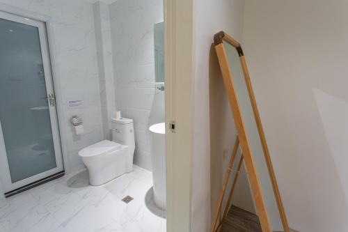 a white bathroom with a toilet and a sink at Bohol Sojourn Villa Alona in Panglao