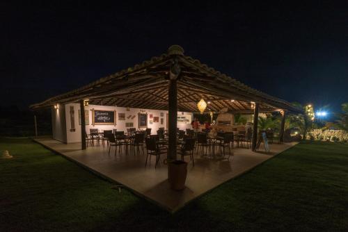 a pavilion with tables and chairs at night at Tree Bies Resort - Oficial in Subaúma