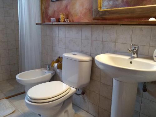 a bathroom with a toilet and a sink at Residencia en Casa de artista in Vistalba
