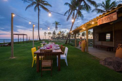 a wooden table with chairs and a table with food on it at Tree Bies Resort - Oficial in Subaúma