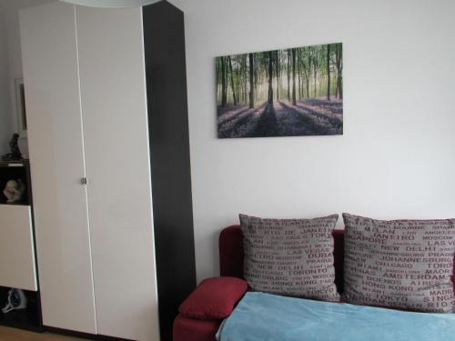 エッセンにあるNoch Gemütlicherのベッドルーム1室(ベッド1台付)が備わります。壁には絵画が飾られています。