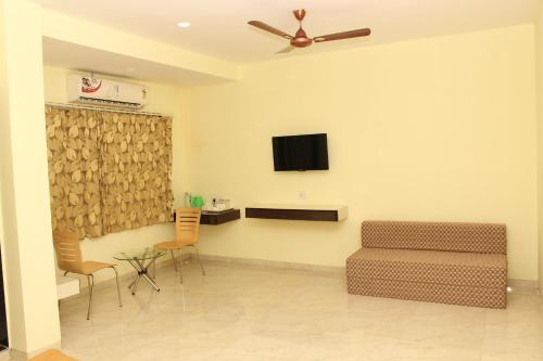 sala de estar con sofá y TV en la pared en SEA WINDS en Ratnāgiri