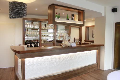 um bar com um balcão de madeira com garrafas de vinho em Ummen Hotel&Restaurant em Barßel