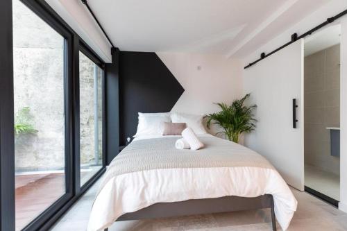 a bedroom with a large bed and large windows at 2 rooms Sea Breeze loft apartment II terrace family Scheveningen The Hague in Scheveningen