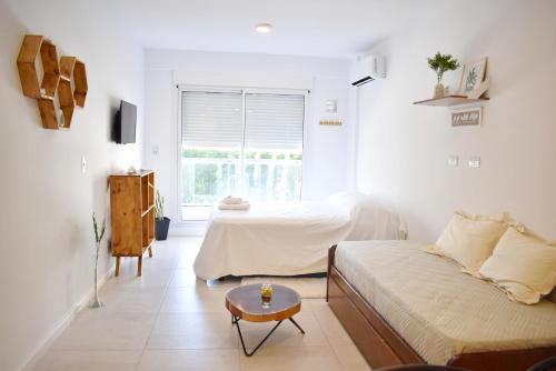 a white bedroom with a bed and a window at Luminosos y modernos departamentos en Rosario in Rosario