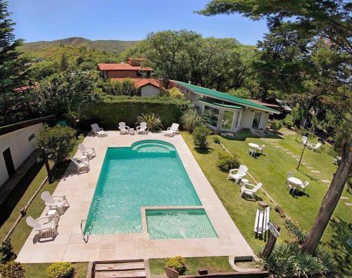 una vista aérea de una piscina con sillas y una casa en Bad-wiessee Apart Hotel & Spa en Villa General Belgrano