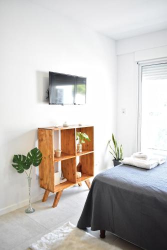a bedroom with a bed and a tv on a wall at Luminosos y modernos departamentos en Rosario in Rosario