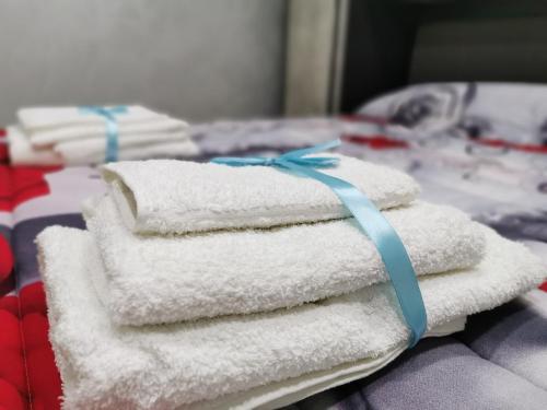 una pila di asciugamani con un nastro blu su un letto di Cuore Di Napoli a Napoli