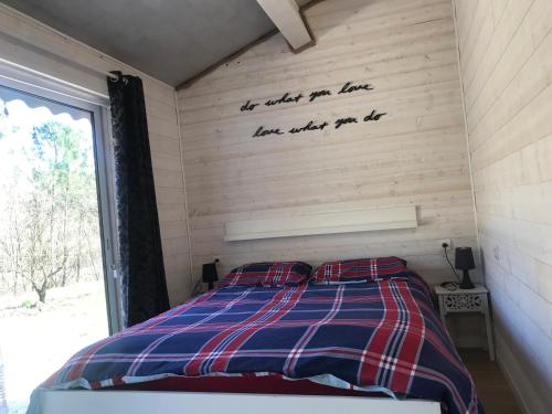 a bedroom with a bed with a sign on the wall at Le Jas d Arcas in Le Martinet