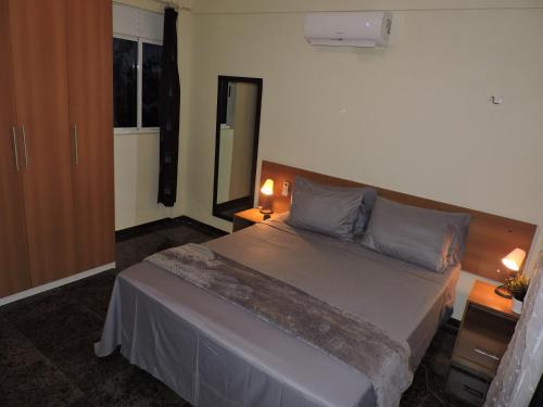 una camera con un grande letto con due lampade di Arituba Tropical a Nísia Floresta